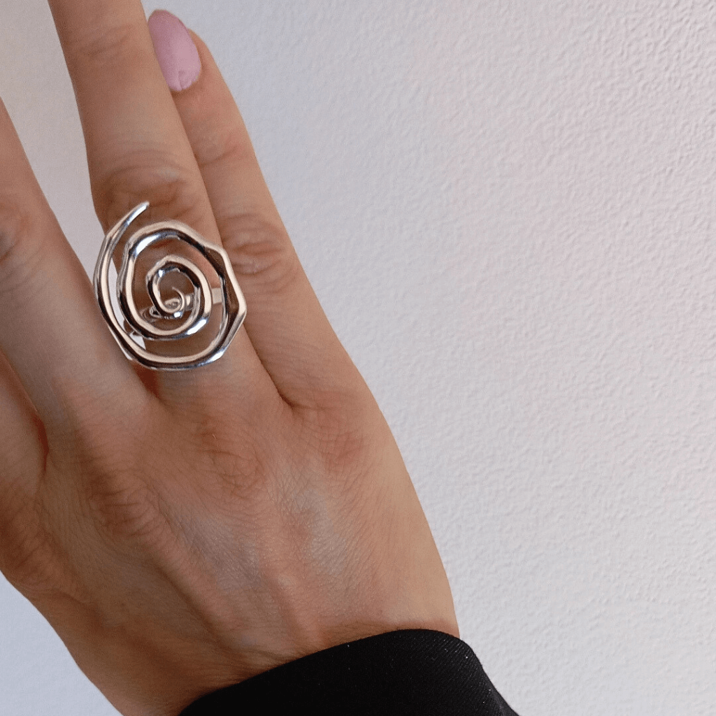 mano vistiendo Anillo forma espiral plateado