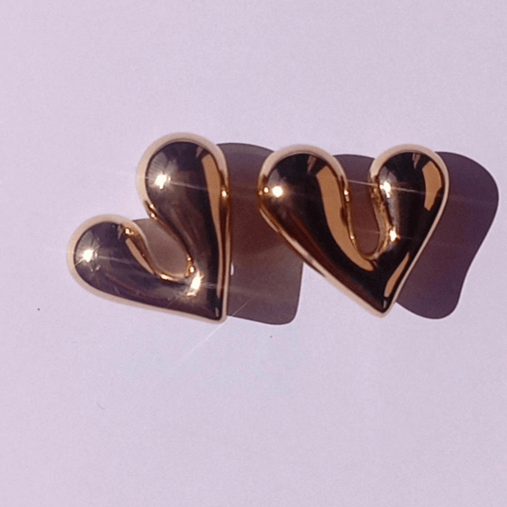 Pendientes, Corazón Uve Oro: Los bellísimos pendientes en forma de corazón hechos en acero inoxidable y bañados en oro de 14K.  Perfectos para darle un toque romántico y elegante a cualquier look.