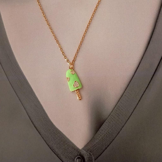Este colgante con forma de paleta de helado en color verde, con pequeños corazones y cristales, es una pieza divertida que aporta ternura y delicadeza. Destaca y expresa tu estilo o con este colgante. ¡Luce audaz con este accesorio en cualquier atuendo!