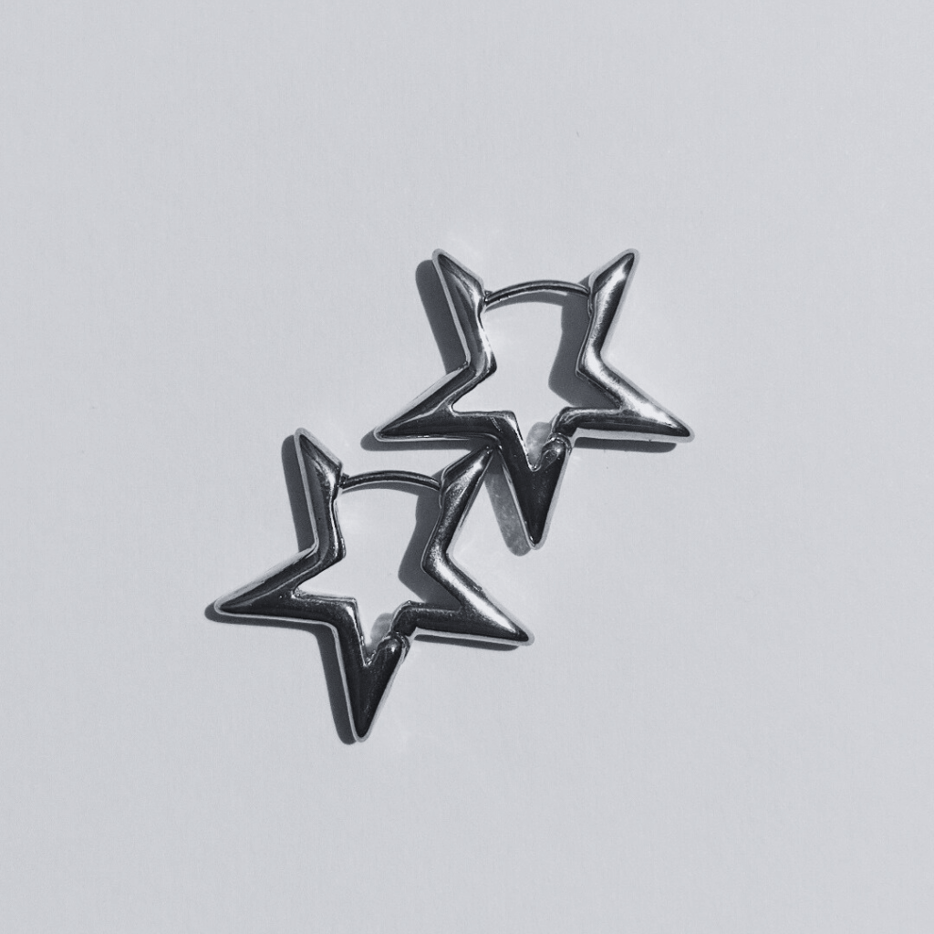 Imagen de unos Pendientes de aro con forma de estrella plateada en fondo blanco