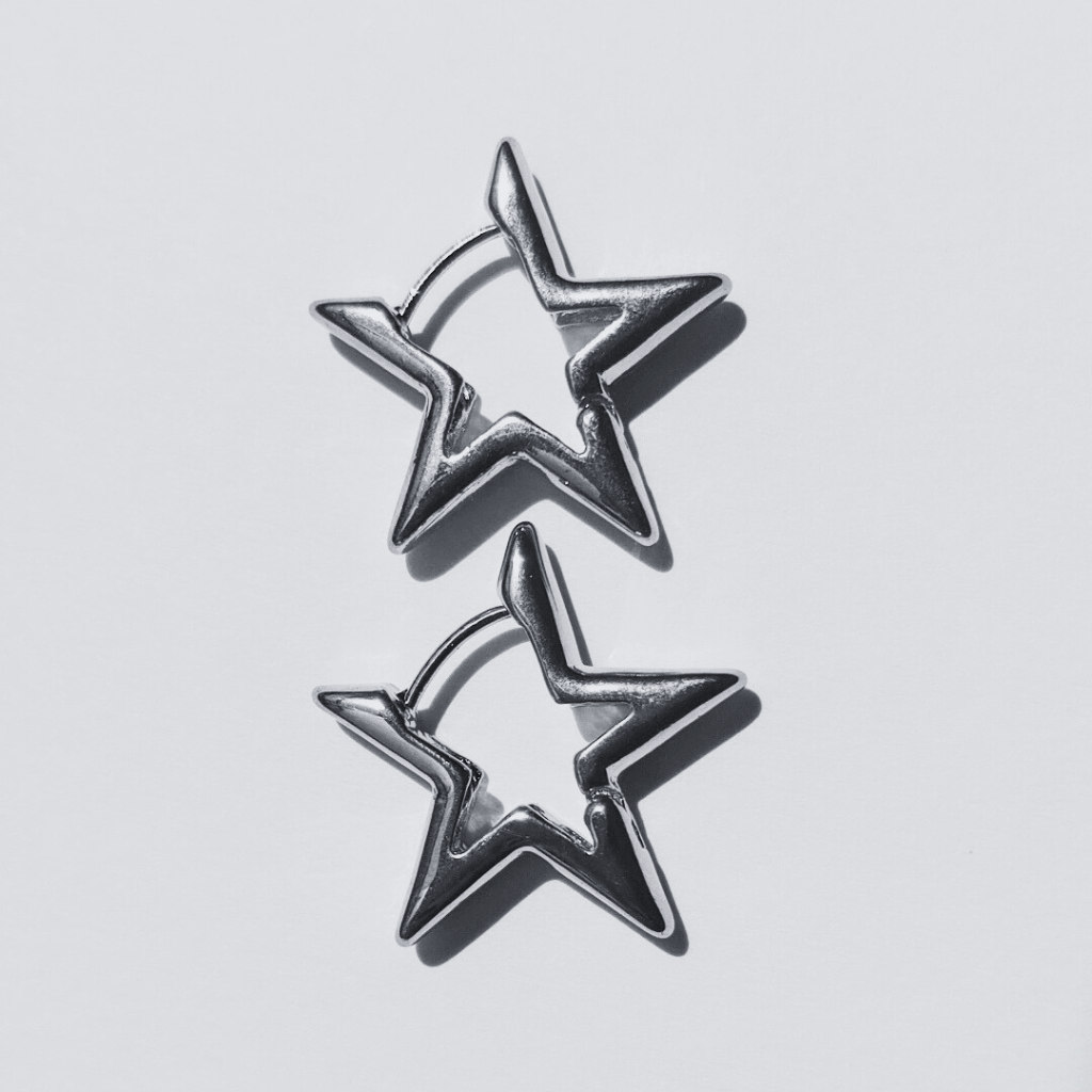Imagen de unos Pendientes de aro con forma de estrella plateada en fondo blanco