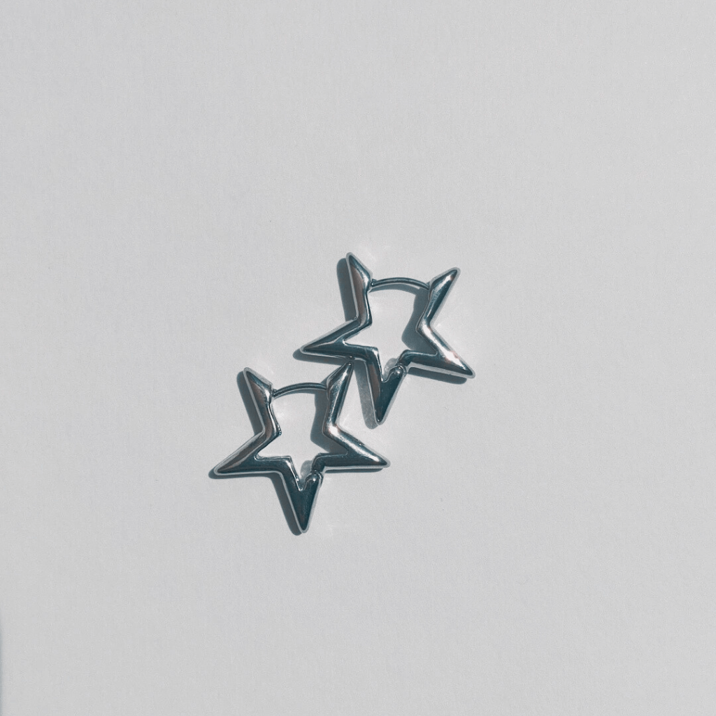 Imagen de unos Pendientes de aro con forma de estrella plateada en fondo blanco