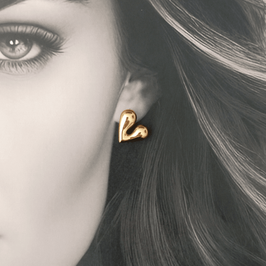 Pendientes, Corazón Uve Oro: Los bellísimos pendientes en forma de corazón hechos en acero inoxidable y bañados en oro de 14K.  Perfectos para darle un toque romántico y elegante a cualquier look.