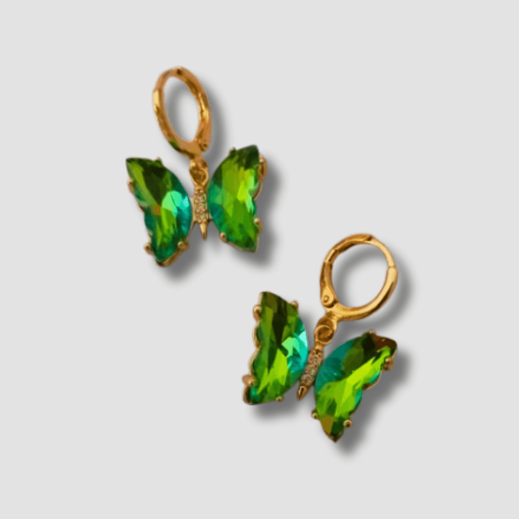 Estos elegantes pendientes en forma de mariposa cuentan con cristales verdes colgando de un mini aro. Con un toque de color y un diseño único, son perfectos para cualquier ocasión. Disfruta de su belleza y añade un toque de sofisticación a tu estilo.