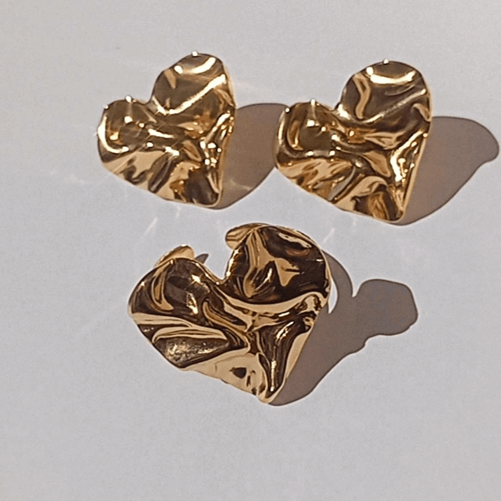 Este elegante anillo de acero bañado en oro de 18k presenta un diseño moderno y de tendencia en forma de corazón corrugado. Añade un toque sofisticado a cualquier atuendo y resalta tu estilo con este accesorio único.