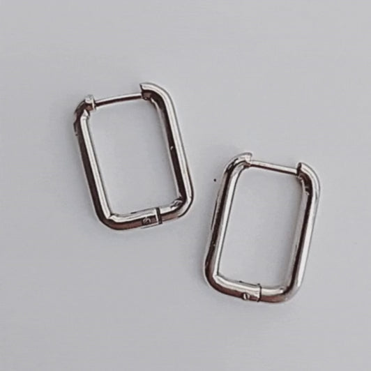 Pendientes Rectangulares Acero. Estos pendientes aros rectangulares de acero en color plateado son el accesorio perfecto para darle un toque de audacia y estilo a tus conjuntos. ¡Haz una declaración de moda con estos pendientes atrevidos!