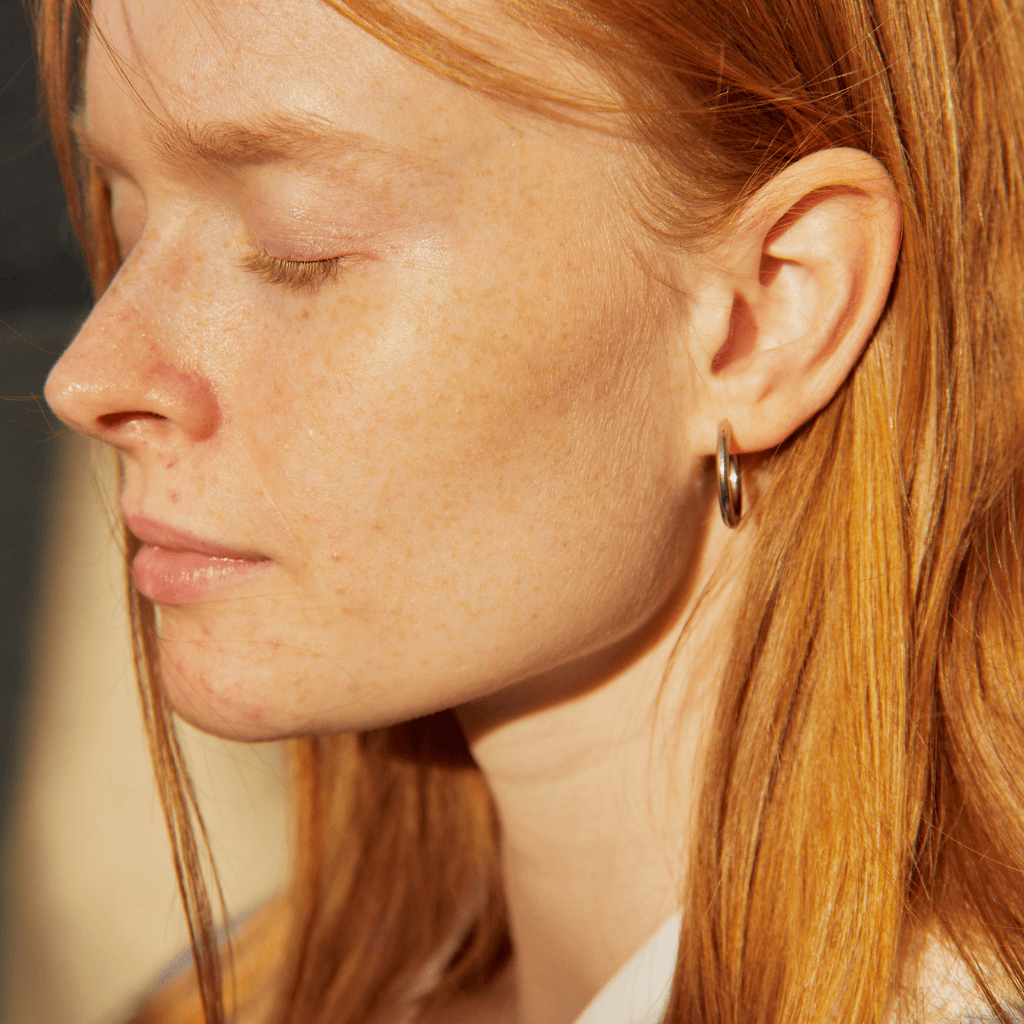 Imagen de mujer usando unos pendientes de aro dorados
