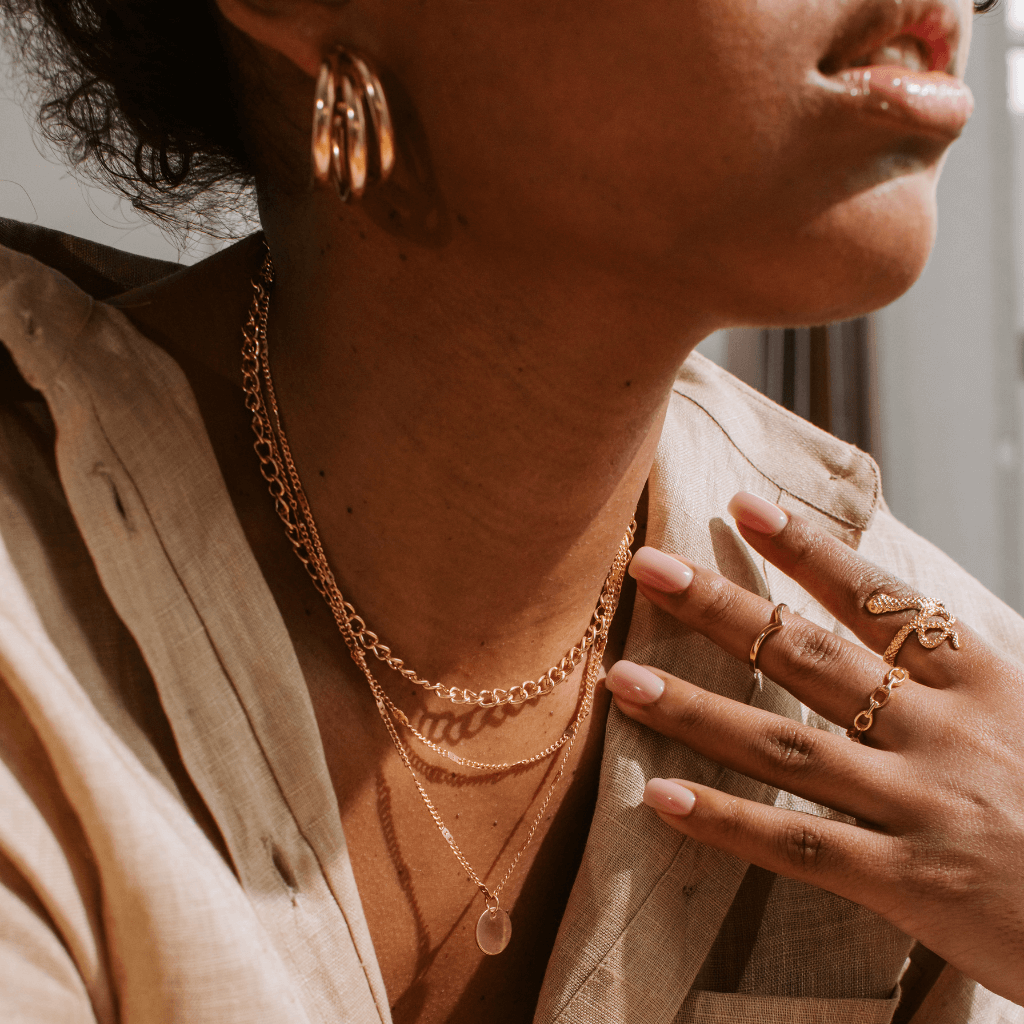 Joyería en tonos Mocha Mousse: anillos, collares y pulseras con piedras marrones, oro rosa y bronce, reflejando la tendencia Pantone 2025