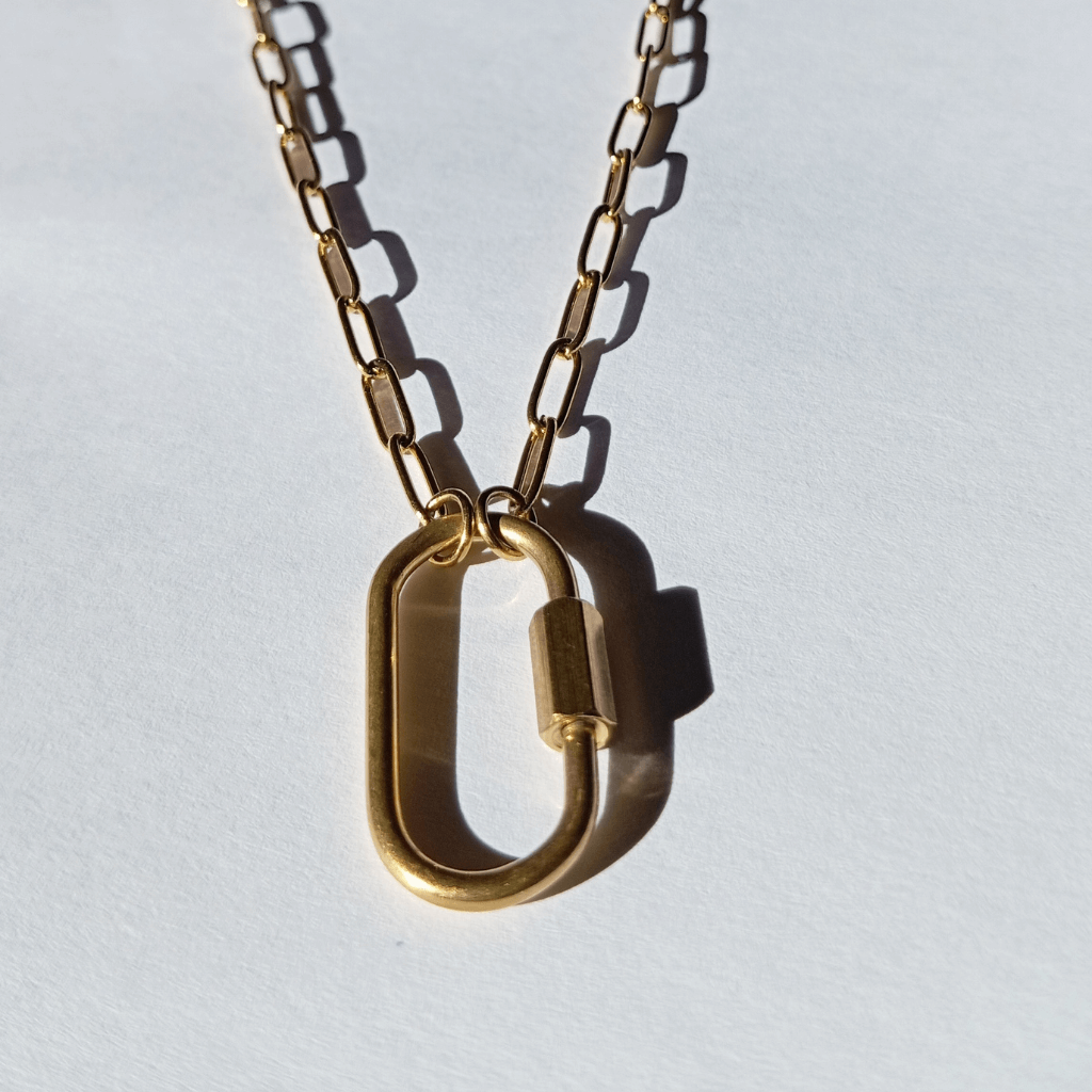 Mujer luciendo collar con varios charms simbólicos, como estrella, corazón y luna, usados como amuletos personales.