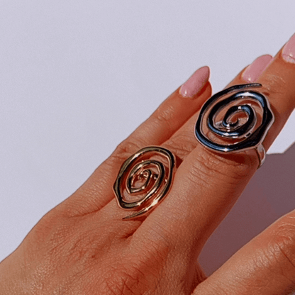 Mano con anillos espirales plateado y dorado