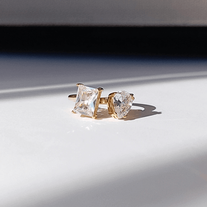 Precioso y elegante Anillo Anillo Abierto Paula Doble Cristal Circón de diferentes diseños uno Cuadrado y otro de corte lagrima o gota  montado en Acero y con Baño en oro 18   Anillo Abierto