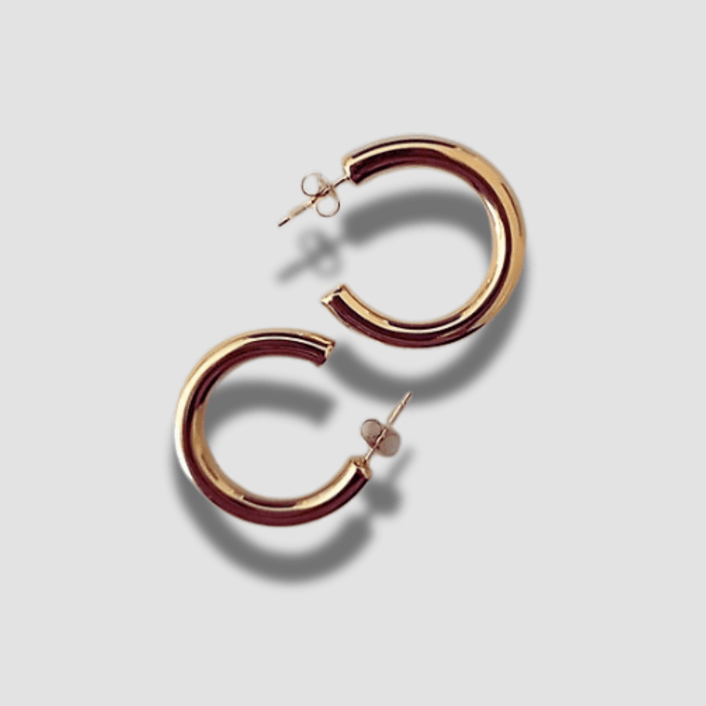 Pendientes aros con acabado dorado. Los pendientes Greta de aro son verdaderamente destacados. Son la perfecta fusión de elegancia y opulencia. Su diseño contemporáneo y tamaño prominente dan un toque atrevido y único a tus atuendos.