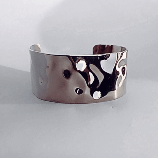 Brazalete Ancho Texturizado Acero metalizado. Superficie ondulada en forma de C permite una fácil colocación y remoción. Hecho de acero, es duradero y resistente, lo que lo convierte en una pieza de joyería de alta calidad para añadir a tu colección. 