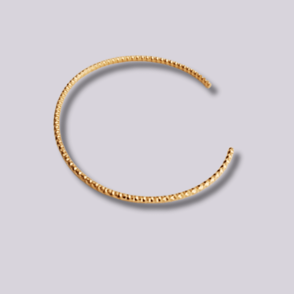 Presentamos un brazalete de acero inoxidable con baño de oro 18k de alta calidad. Con un hermoso y delicado diseño que brinda un efecto de Tronchón o cadena rígida. Perfecta como complemento a otras pulseras-brazaletes, para apilar o completar tu colección. Realizado sin níquel, lo que la convierte en antialérgica y hecha con la más alta calidad.