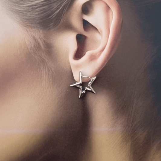 Mujer vistiendo Pendientes de aro forma de estrella plateada 