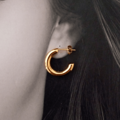 Mujer vistiendo unos Imagen de pendientes de aro forma C gruesos 