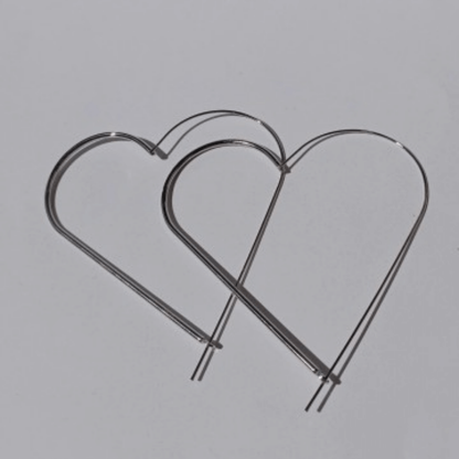 Imagen de Pendientes Aro Maxi XL Corazón exagerado plateados de hhedderich.com en fondo blanco y con sombra de sol
