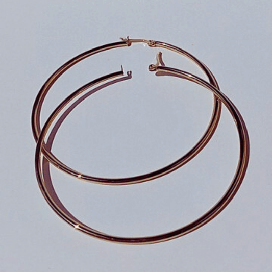 Imagen de unos Pendientes De Aro Hilo Fino Oro Acero de 7 centímetros de diámetro en fondo blanco puestas al sol