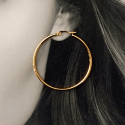 Imagen de mujer vistiendo unos Pendientes De Aro Hilo Fino Oro Acero de 7 centímetros de diámetro como guiade talla de hhedderich