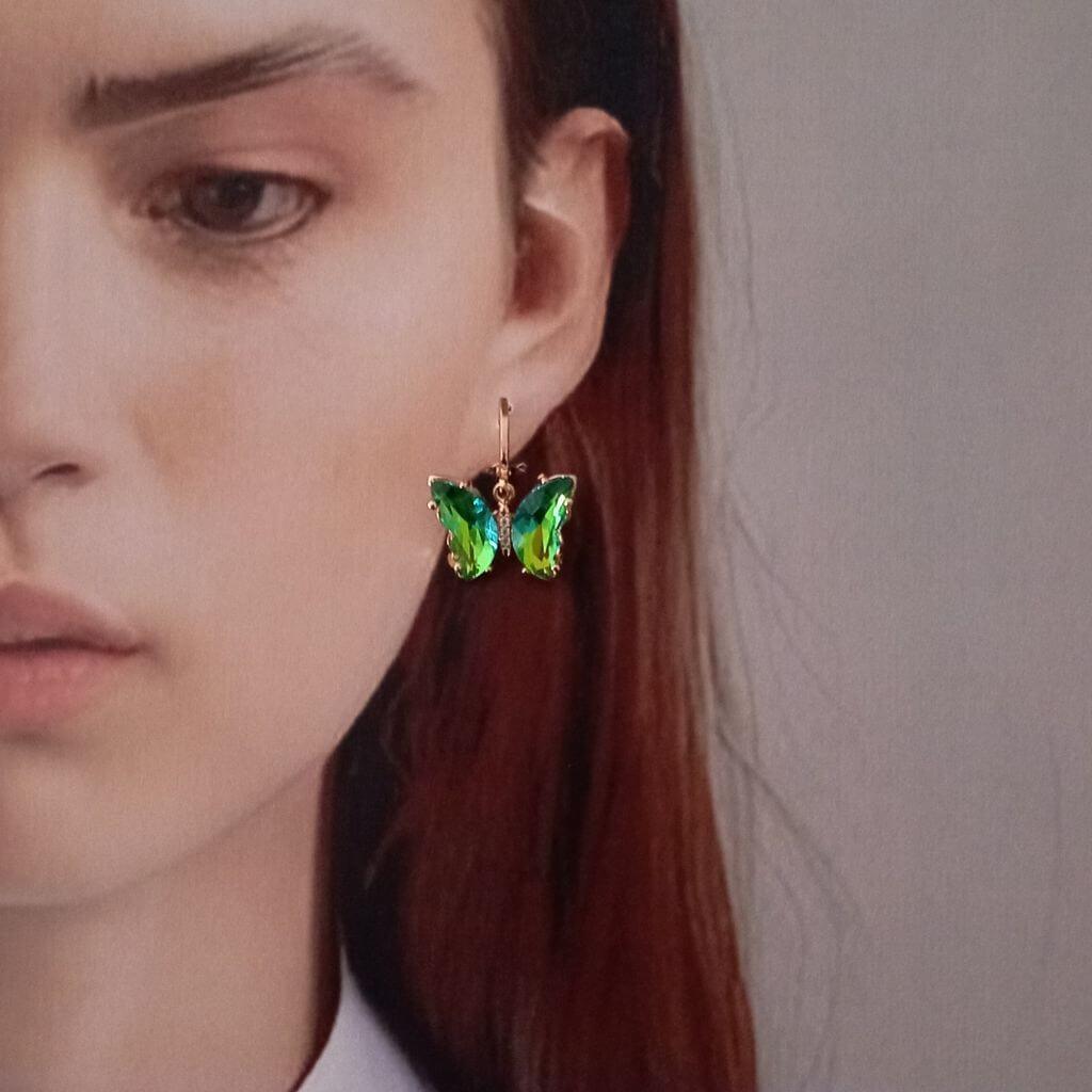 Estos elegantes pendientes en forma de mariposa cuentan con cristales verdes colgando de un mini aro. Con un toque de color y un diseño único, son perfectos para cualquier ocasión. Disfruta de su belleza y añade un toque de sofisticación a tu estilo. 