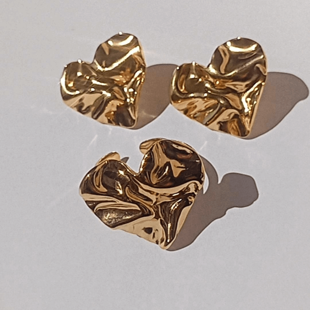 Este elegante anillo de acero bañado en oro de 18k presenta un diseño moderno y de tendencia en forma de corazón corrugado. Añade un toque sofisticado a cualquier atuendo y resalta tu estilo con este accesorio único. 