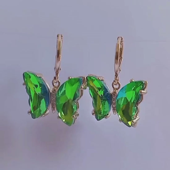 Estos elegantes pendientes en forma de mariposa cuentan con cristales verdes colgando de un mini aro. Con un toque de color y un diseño único, son perfectos para cualquier ocasión. Disfruta de su belleza y añade un toque de sofisticación a tu estilo.